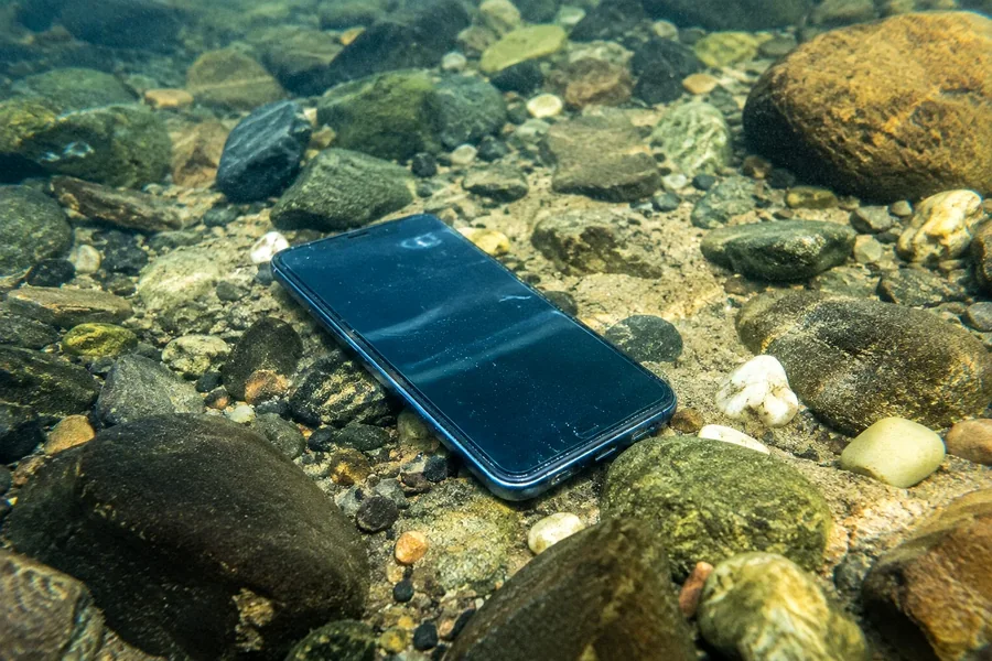 Verlorenes Handy auf dem steinigen Grund eines Sees